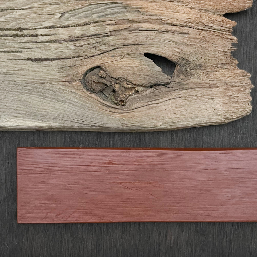 Iron oxide red linseed paint on rough sawn timber. Historic colors from old fashioned paint formulas.